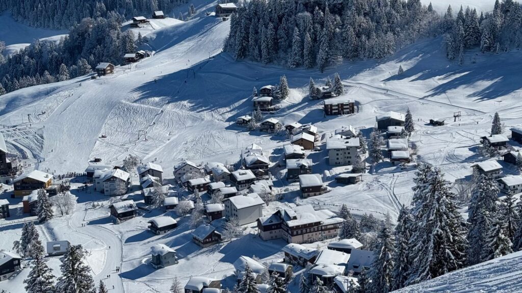Station de ski enneigée dans les Alpes suisses, avec chalets et pistes