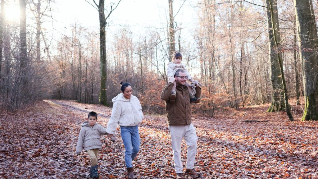 Famille avec enfants se promenant sur un sentier forestier en automne