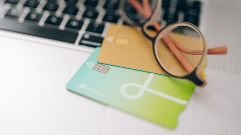 Cartes bancaires et lunettes posées sur le clavier d'un ordinateur portable