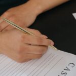 Main tenant un stylo et remplissant un document administratif sur un bureau
