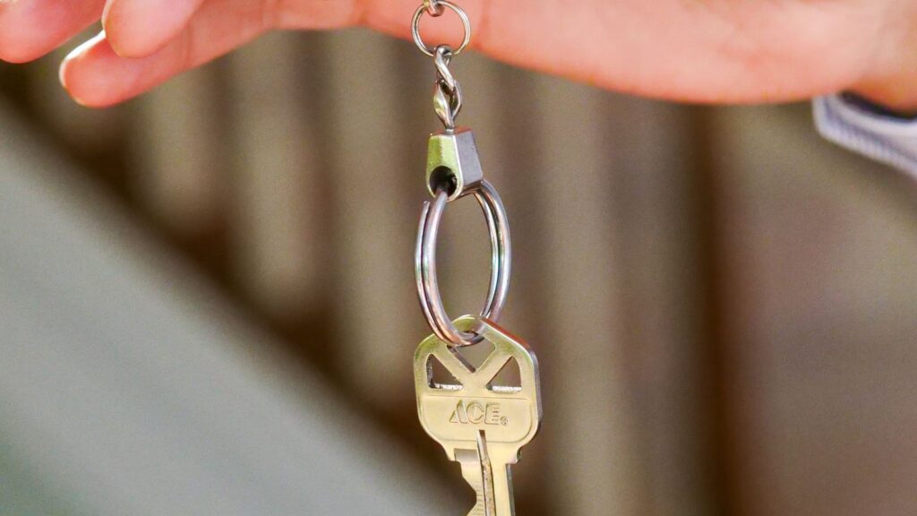 Gros plan sur une main tenant la clé d'un logement
